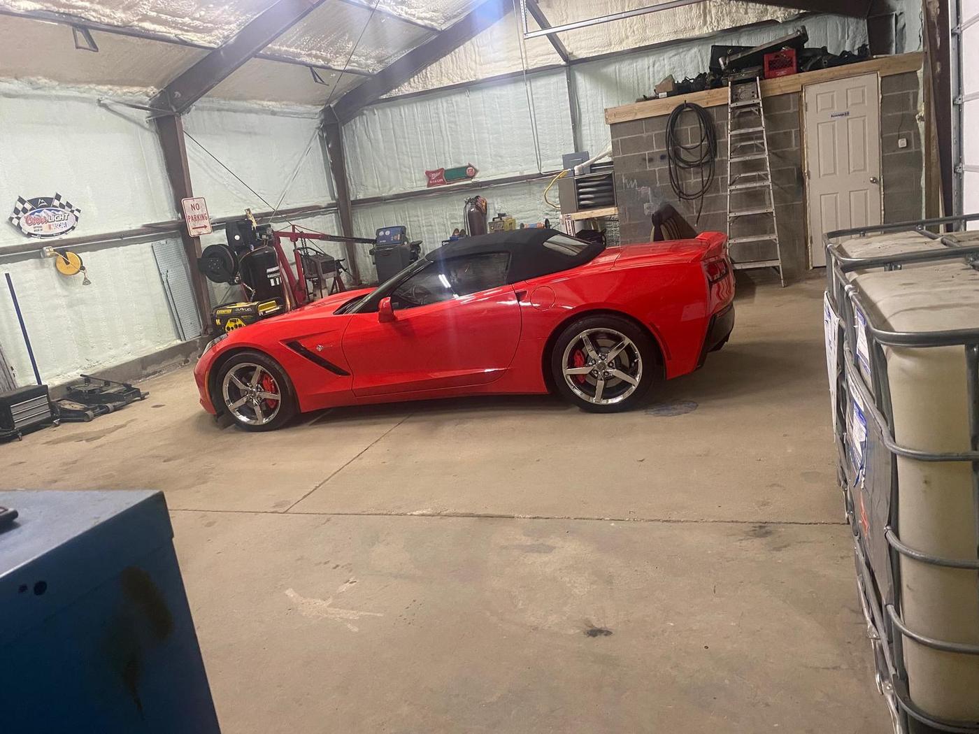 Red Corvette convertible parked inside the shop